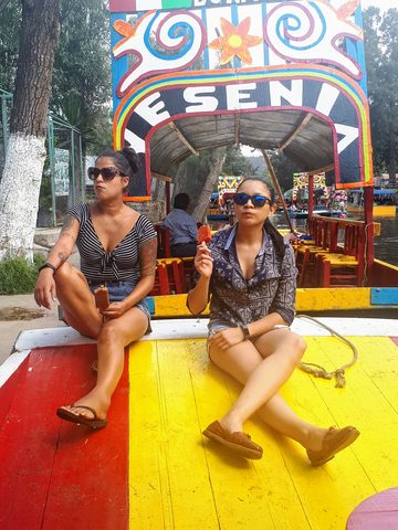 Two women enjoying popsicles on a colorful boat in an outdoor setting. MJ and Katherine, April 18, 2019
