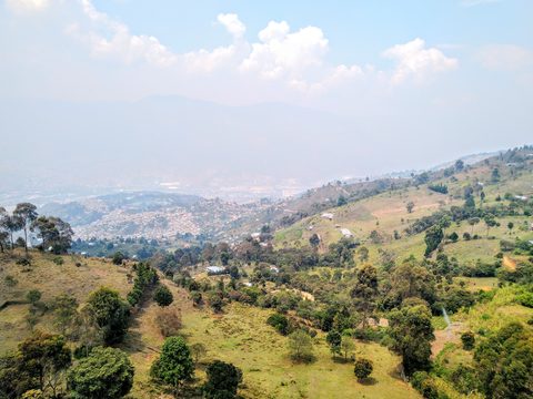 A wide landscape view overlooking a valley with a town nestled among rolling로 ```. Medellin, Colombia, March 7, 2020