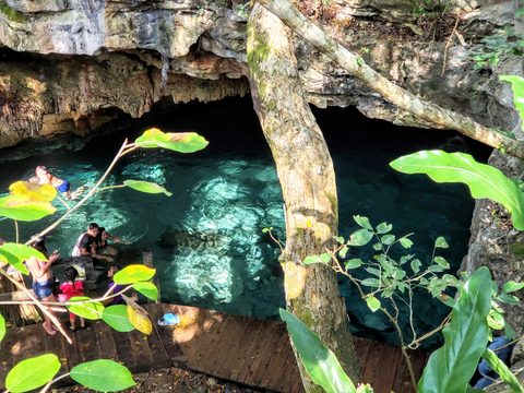 A group of people enjoying the clear waters at an outdoor swimming hole. Chochola, Mexico, December 1, 2019