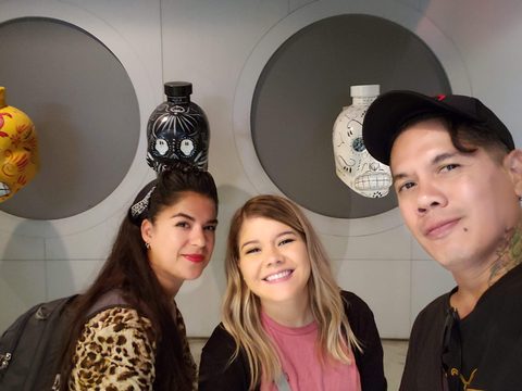 Three people are smiling for a selfie in front of a display of decorative ceramic vessels. MJ and Cisco and Liz, Museum of Tequila and Mezcal, Cuauhtemoc, Mexico, September 29, 2019