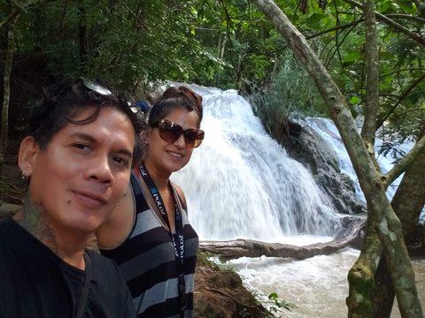 A man and a woman pose for a selfie in front of a cascading waterfall. MJ and Cisco, Jerusalen, Mexico, November 17, 2019
