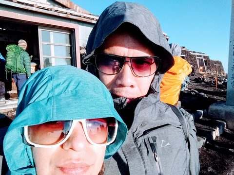 Two people wearing hooded jackets and sunglasses pose for a selfie outdoors. MJ and Cisco, Fujikawaguchiko, Japan, July 8, 2017