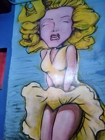 A colorful mural of a woman with blonde hair wearing own own```json way. Guanajuato, Mexico, October 6, 2019