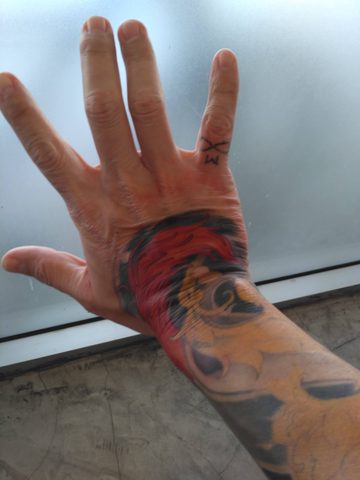 A close-up view of a person'up colorful tattoo tattoo tattoo on a person's hand and forearm:. Bang Na, Thailand, May 13, 2016